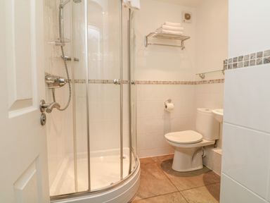 A bathroom with a shower enclosure a toilet a towel rack and towels at Beach Lodge in Woolacombe