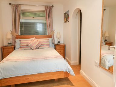 A bedroom with a double bed and striped bedding in Beach Lodge Woolacombe