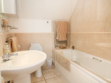 A bathroom with a sink toilet bathtub and towels at Beach Lodge in Woolacombe