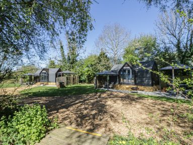 An outdoor area with several cabins and a deck at Acorn Lodge At Bridge Lake Farm & Fishery, Chacombe