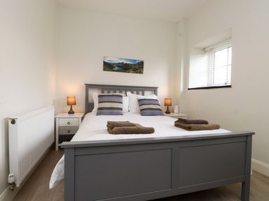 A bedroom with a bed and bedside table at Pen Y Cefn in Pen Y Cefn