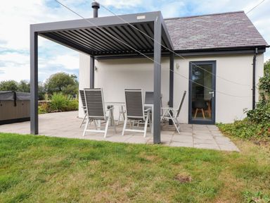 An outdoor seating area with a table and chairs at Pen Y Cefn
