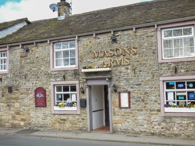 Stone building with sign reading Masons Arms and windows with flower boxes at Otter Lodge in Gargrave