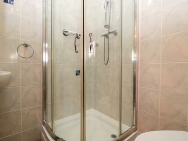 A bathroom with a corner shower enclosure and a showerhead at The Oak Lodge near Lyme Regis