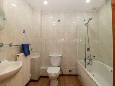 A bathroom with a toilet sink bathtub shower and towel rack at The Oak Lodge near Lyme Regis