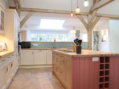 A kitchen with an island and hanging lights at The Anchorage @ Nables Farm in Upper Seagry