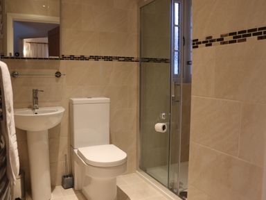 A bathroom with a pedestal sink toilet and glass shower enclosure at The Anchorage @ Nables Farm in Upper Seagry