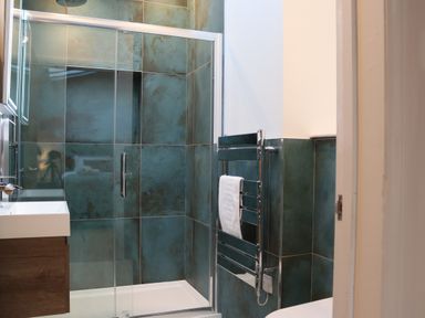 A bathroom with a shower enclosure a towel rack and a sink at The Anchorage @ Nables Farm in Upper Seagry
