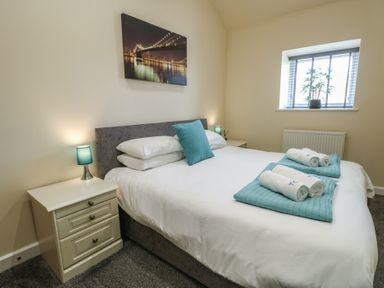 A bedroom with a double bed side tables lamps and a window at Ty Cuddfan in Llangoed