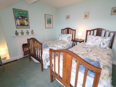 A bedroom with two wooden single beds and a nightstand with a lamp at Carriguisnagh in Ballycastle