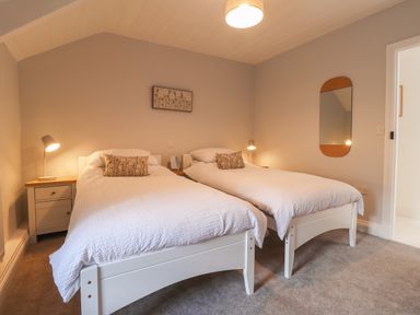 A bedroom with two single beds and bedside tables with lamps at Awelfa Newport Pembrokeshire