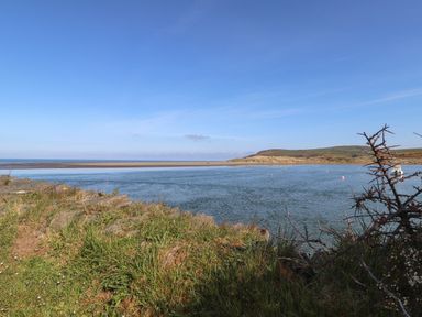 A river with grassy shore and hills in the background at Awelfa in Newport Pembrokeshire