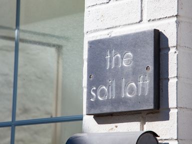 A close up of a wall sign that says the sail loft on a white brick wall at The Sail Loft in St Ives