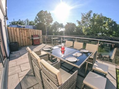 An outdoor patio with a dining table set and a barbecue grill at Swallows Dip in Honiton
