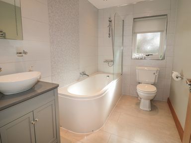 A bathroom with a bathtub shower combination toilet and sink at Treetops Otterburn