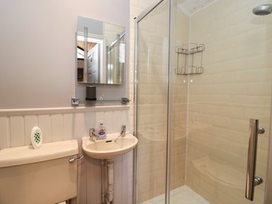 A bathroom with a beige toilet sink and shower at Pine Tree in Otterburn