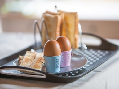 A breakfast tray with two boiled eggs in egg cups toast slices and toast holders at Pine Tree in Otterburn