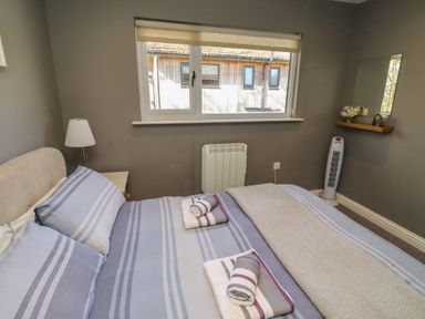 A bedroom with a bed and window at Barn Owl in Otterburn