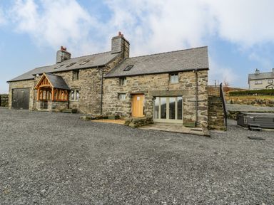 A stone house with slate roof gravel driveway wooden door and external staircase at Hen Dy Craig Yr Ronwy in Capel Celyn near Bala
