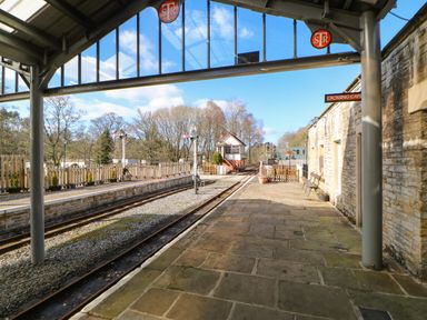 A railway platform with tracks benches and a signal box at 1 The Stables in Alston