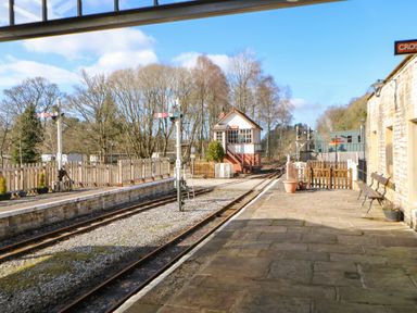 A railway platform with rails signposts and a signal box at 1 The Stables in Alston