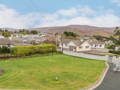 A residential area with houses green lawn and hills in the background at Loughanure Lake View in Loughanure County Donegal