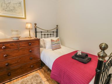A bedroom with a single bed and a wooden chest of drawers at Swn yr Afon in Beddgelert