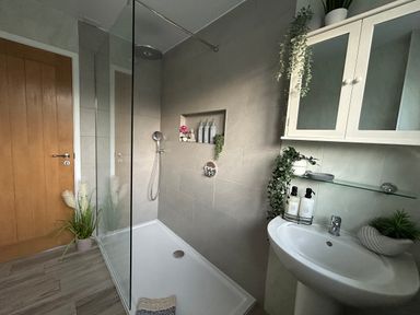 A bathroom with a shower and sink at Island View Cottage High Hauxley near Amble