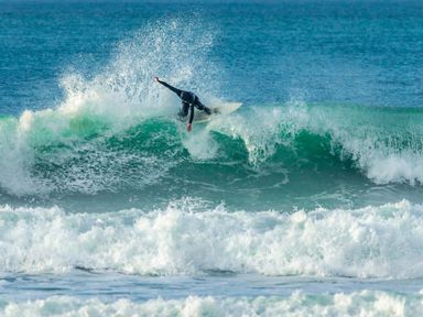 A person surfing on a wave in the ocean at Garden View in Quintrell Downs near Newquay