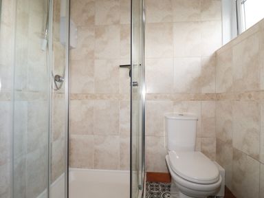 A bathroom with a shower enclosure and a toilet at Garden View in Quintrell Downs near Newquay