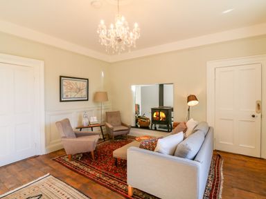 A sitting room with a sofa two armchairs a coffee table and a wood stove at Carleys Bridge House in Carleys Bridge near Enniscorthy County Wexford