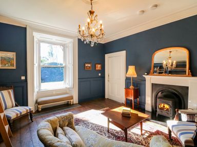 A living room with a fireplace mirror chandelier and furniture at Carleys Bridge House in Carleys Bridge near Enniscorthy County Wexford
