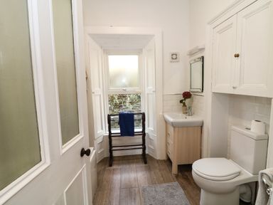 A bathroom with a toilet sink mirror towel rack and window at Carleys Bridge House in Carleys Bridge near Enniscorthy County Wexford