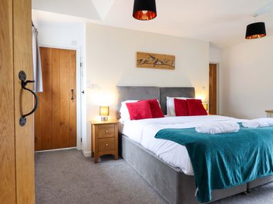 A bedroom with a double bed and nightstand at Bwthyn Y Bugail (Shepherd's Cottage) Pedairffordd near Llanrhaeadr-Ym-Mochnant