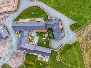 An aerial view of an outdoor area with various buildings and grass at Bwthyn Y Bugail (Shepherd's Cottage) Pedairffordd near Llanrhaeadr-Ym-Mochnant