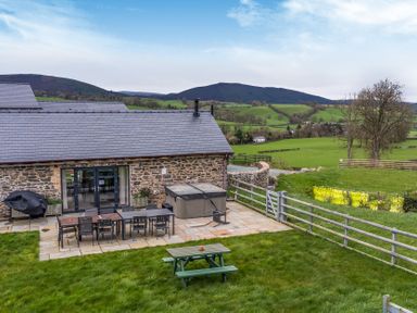 An outdoor area with a table and chairs at Bwthyn Y Bugail (Shepherd's Cottage) Pedairffordd near Llanrhaeadr-Ym-Mochnant