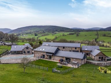 A house with a garden and outdoor seating at Bwthyn Y Bugail (Shepherd's Cottage) Pedairffordd near Llanrhaeadr-Ym-Mochnant