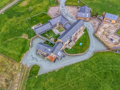 An aerial view of a property with multiple buildings and greenery at Y Granar (The Granary) Llanrhaeadr-Ym-Mochnant