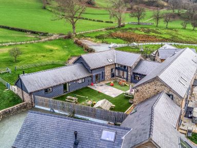 An outdoor area with several houses and a patio at Y Stabl (The Stable) Llanrhaeadr-Ym-Mochnant
