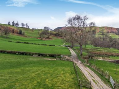 A landscape with green fields and a winding path at Y Stabl (The Stable) Llanrhaeadr-Ym-Mochnant
