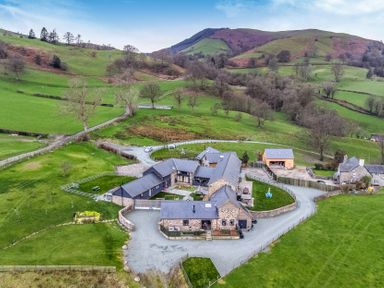 An outdoor view of a house and surrounding fields at Y Stabl (The Stable) Llanrhaeadr-Ym-Mochnant