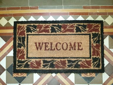 A welcome doormat on a patterned tiled floor at Sunnymeade in Buxton Norfolk