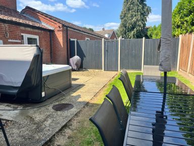 A garden with a hot tub, table and chairs at Sunnymeade, Buxton, Norfolk