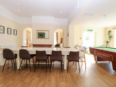 A dining room with a table and chairs and a pool table at Sunnymeade in Buxton, Norfolk