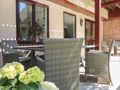 A patio area with wicker chairs and a table outside a building at 32 Trevithick in Hayle