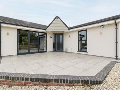 A tiled patio area with black framed glass doors and windows at Strawberry Stables in Iwood near Congresbury