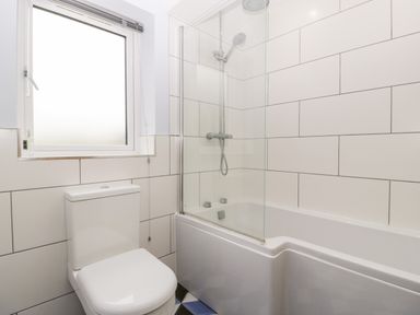 A bathroom with a toilet and a bathtub with a shower at Strawberry Stables in Iwood near Congresbury