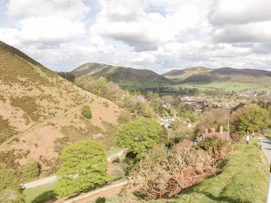 A landscape view of hills trees and houses in a rural area at Callow Fold in Dinchope near Craven Arms