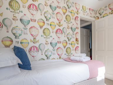 A bedroom with a bed and hot air balloon wallpaper at Field Head House in Graythwaite near Hawkshead