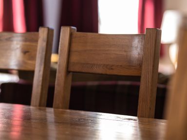 A close-up of wooden chair backs and wooden table in a room at Grubbings in Graythwaite near Hawkshead